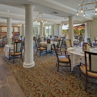 An elegant dining area with neatly arranged tables and chairs, featuring classic interior design elements.