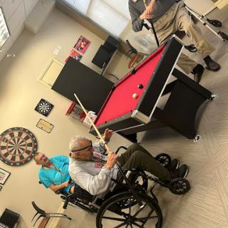 Residents enjoying a game of billiards in their recreational area.