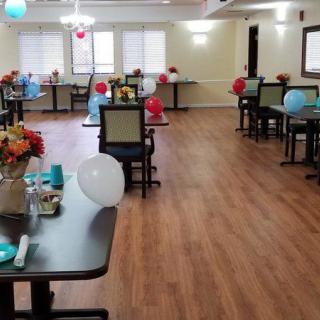 An indoor dining area with decorated tables and colorful balloons.