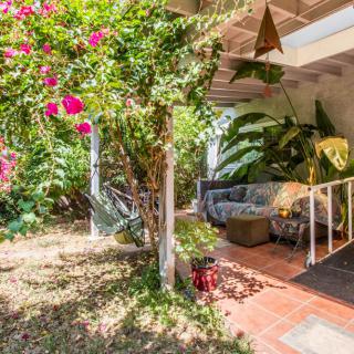 A cozy outdoor patio surrounded by lush greenery and vibrant flowers.