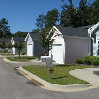 A suburban neighborhood with several houses, driveways, and well-maintained lawns.