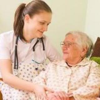 A nurse providing care and support to an elderly woman.