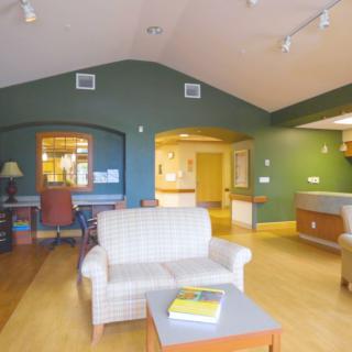 A cozy living room with green walls, featuring a comfortable couch and a wooden table.