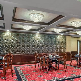 Elegant restaurant interior with intricate wall design and luxurious chandeliers.