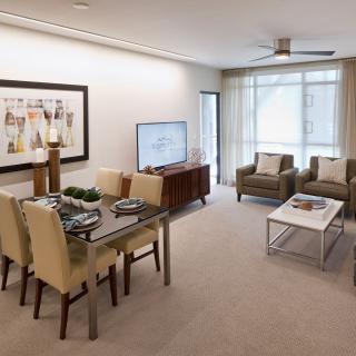 A modern living and dining area with neutral tones, featuring a television, stylish furniture, and wall art.