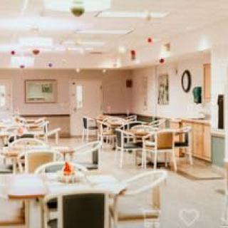 A well-lit, empty cafeteria with neatly arranged tables and chairs.