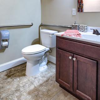A bathroom with a toilet, sink, and vanity.