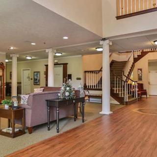 Spacious living area with elegant staircase and comfortable seating.