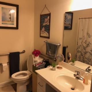 A cozy bathroom with modern amenities and decorative wall art.