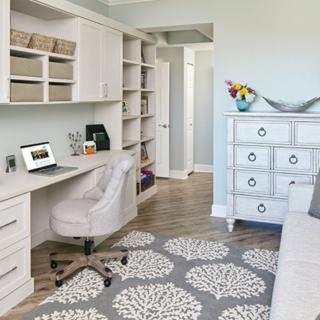 Modern home office with a sleek desk, comfortable chair, and ample shelving for storage.
