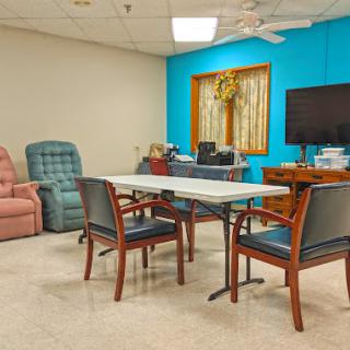 A cozy meeting room featuring a table and chairs, accented by a television and comfortable seating.
