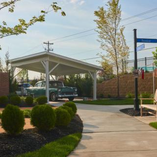 A neatly landscaped driveway with a carport and well-maintained shrubbery.