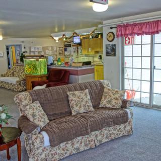 A cozy living room featuring a floral-patterned sofa, fish tank, and sliding patio doors.