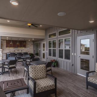 A cozy outdoor patio with comfortable seating and a kitchen area.
