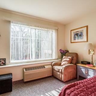 A cozy bedroom corner with a comfortable chair by the window.