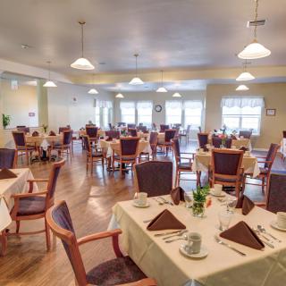 An elegantly set dining room with neatly arranged tables and chairs.