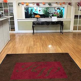 A welcoming reception area featuring a hardwood floor, decorative fish tank, and a simple table.
