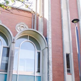 A close-up view of a brick building with arched windows and a modern design.