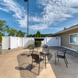 An outdoor patio area with chairs and a table under a clear sky.