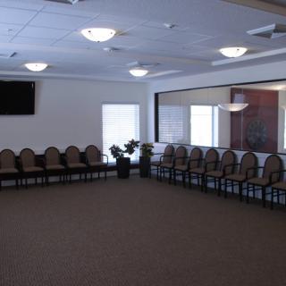 An empty meeting room with chairs arranged around the perimeter.
