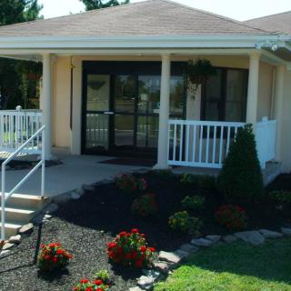 A cozy house with a covered porch and a neatly landscaped front yard.