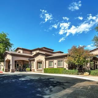 A beautifully designed residential building set against a clear blue sky.