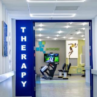 A modern therapy room equipped with exercise machines in a clinical setting.