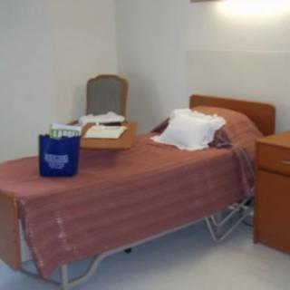 A hospital room with a bed and bedside table.