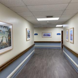 A well-lit hospital corridor adorned with framed artwork.