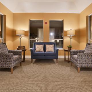 A cozy living room with a symmetrical arrangement of sofas and armchairs.