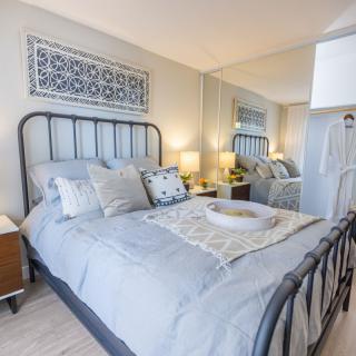 A cozy bedroom with elegant decor, featuring a metal frame bed, soft bedding, and stylish nightstands.
