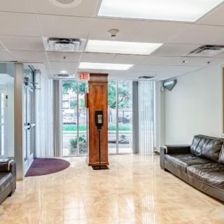 A modern office lobby with leather sofas and glass doors, providing a welcoming waiting area.