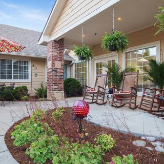 A welcoming porch with rocking chairs and lush plants, creating a cozy outdoor space.