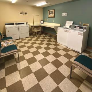 A cozy laundry room with washing machines and a waiting area.