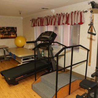 A therapy room equipped with exercise machines and equipment for rehabilitation.