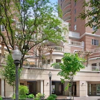 A modern residential building with surrounding trees and greenery.