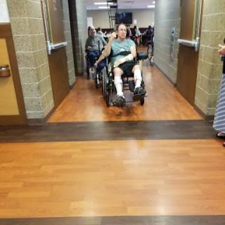 A person in a wheelchair being assisted down a hallway during an event.