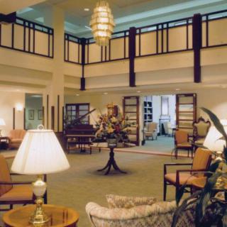 A spacious and elegantly decorated lobby with comfortable seating and a grand chandelier.