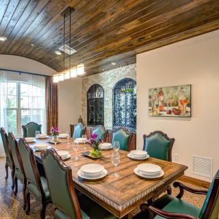 A beautifully set dining room with a wooden table and elegant chairs.
