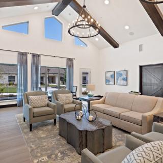A modern living room with high ceilings, featuring a comfortable sofa set and elegant decor.