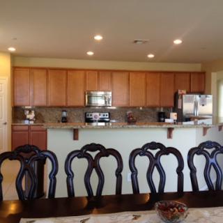 A modern kitchen and dining area featuring wooden cabinets and a stylish table with chairs.