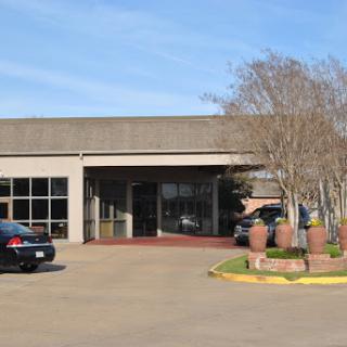 A modern commercial building with a welcoming entrance and surrounding landscaping.