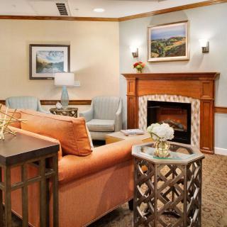 A cozy living room with a warm color palette, featuring a comfortable sofa, decorative fireplace, and stylish artwork.