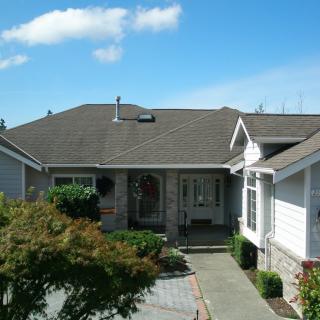 A suburban house with a landscaped driveway and clear blue sky.