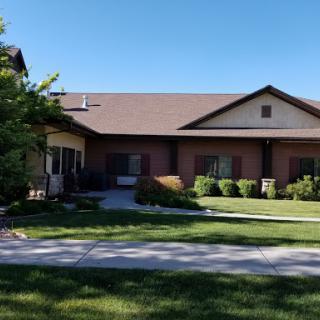A charming residential home with a well-maintained lawn under a clear blue sky.