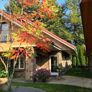 A charming house surrounded by autumn foliage and a well-maintained garden.