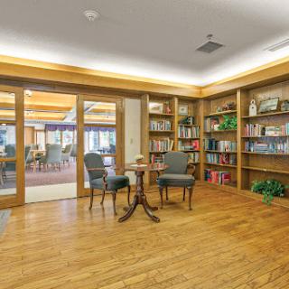 A cozy reading nook featuring bookshelves, comfortable seating, and warm lighting.