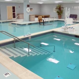 An indoor swimming pool designed for aquatic therapy and rehabilitation exercises.