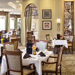 A beautifully decorated restaurant dining area with elegantly set tables and comfortable seating.