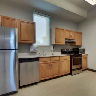 A modern kitchen with stainless steel appliances and wooden cabinets.